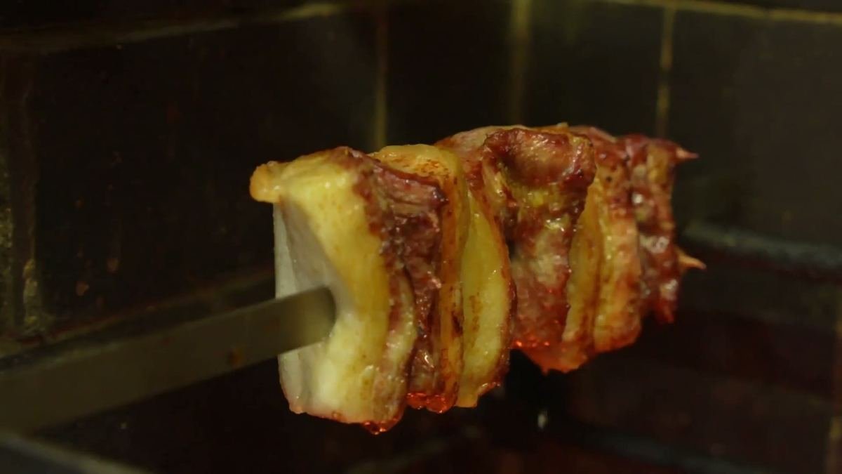 A skewer of picanha with a fat cap being grilled for churrasco at Brasa